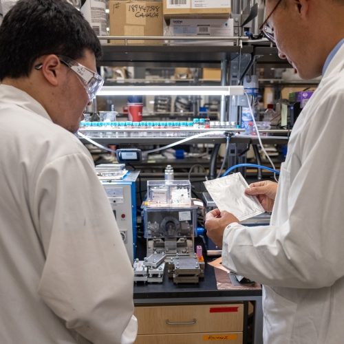 Two researchers examining a device in the lab.