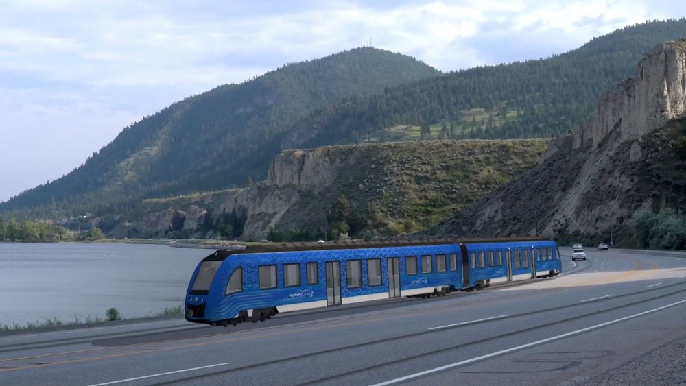 An artist rendering of a light rail train running in front of Okanagan Lake.