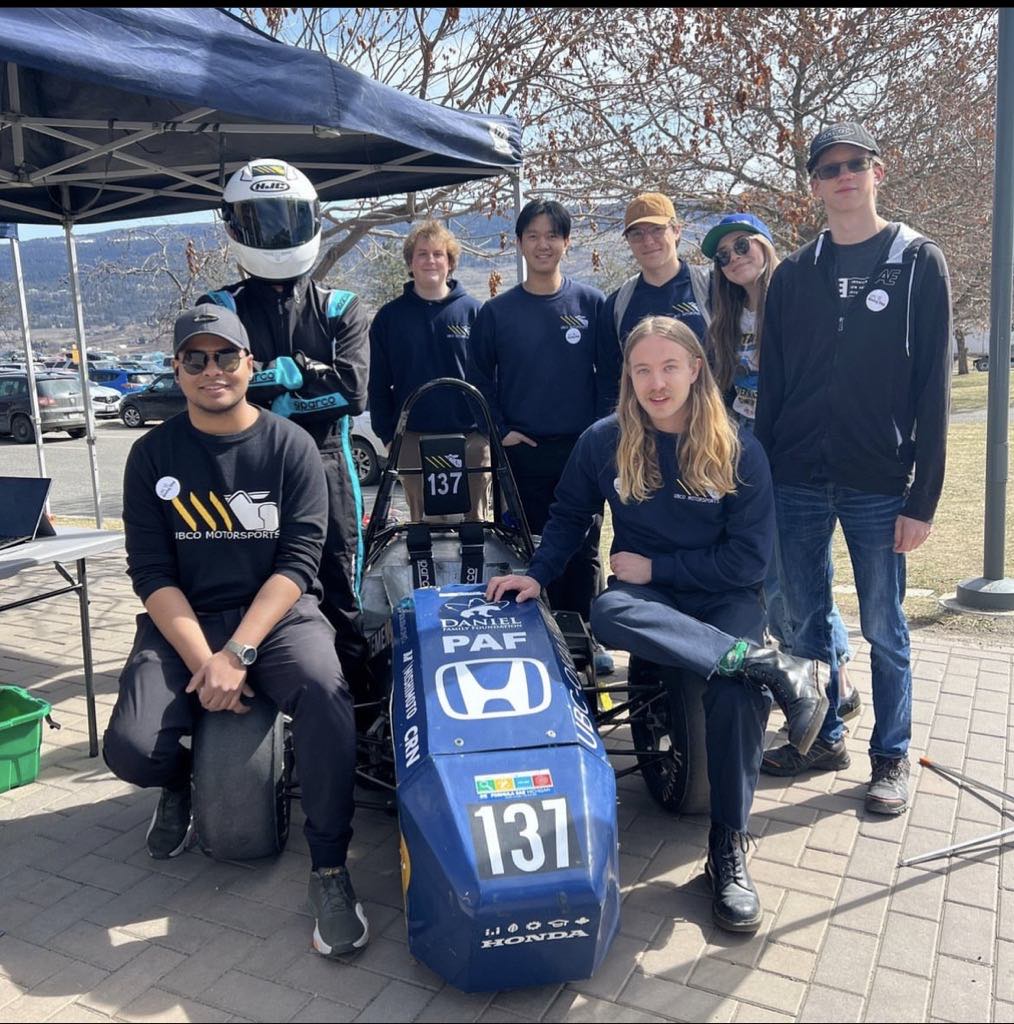 Group of people surrounding Okanagan Motorsports car
