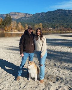 Conor and his wife Cydney, standing together with their dog.